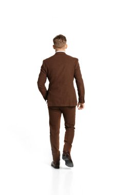 Zarif iş adamının arka planı, 80 'lerin kahverengi takım elbiseli genç adam, 70' lerin moda tarzı beyaz stüdyo arka planında izole edilmiş. Güzellik, moda, iş