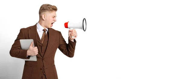 Shouting young man, student wearing suit of 80s, 70s fashion style screaming at megaphone isolated on white studio background. Beauty, fashion, music — Stock Photo, Image