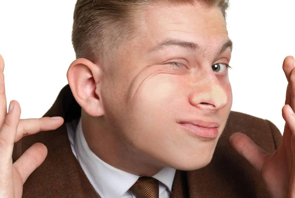 Jonge knappe man, student leunde tegen transparant glas geïsoleerd op witte studio achtergrond. Een close-up. Concept van menselijke emoties, gezichtsuitdrukking — Stockfoto