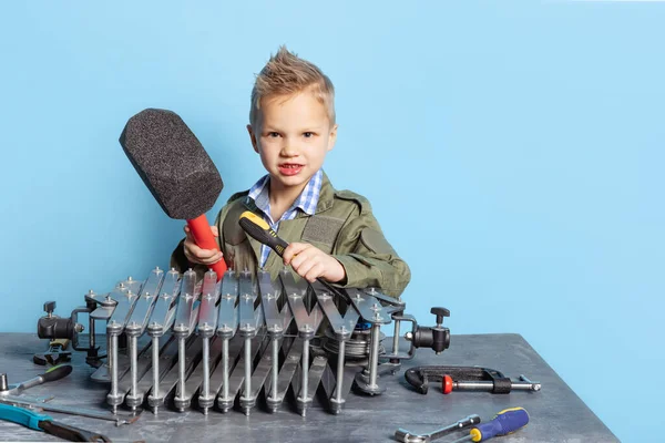 Comic porträtt av förskolan pojke, unge i bild av bilmekaniker eller montör i fängelsehålor med arbetsverktyg som har kul isolerad på blå bakgrund. — Stockfoto