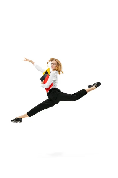 Dynamiczny portret młodej ładnej dziewczyny noszącej ubrania w stylu biznesowym skaczących z folderów izolowanych na białym tle. Finanse, balet, sztuka, biznes, koncepcja piękna. — Zdjęcie stockowe