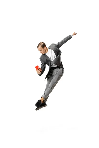 Hombre joven en traje gris de negocios bailando, saltando, volando aislado sobre fondo blanco. Negocios, arte, movimiento, acción, creatividad, concepto de inspiración. — Foto de Stock