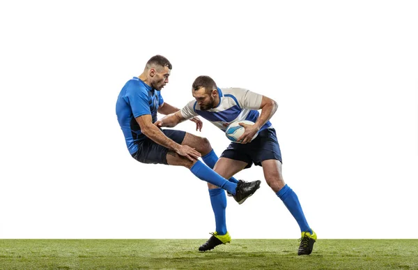 Beyaz arka planda izole edilmiş çimlerde rugby oynayan erkek rugby oyuncularının dinamik portresi. Spor, etkinlik, sağlık, hobi, meslek kavramı — Stok fotoğraf