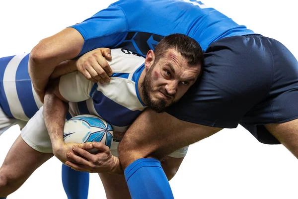 Retrato dinámico de jugadores de rugby masculinos jugando al rugby en un campo de hierba aislado sobre fondo blanco. Deporte, actividad, salud, afición, concepto de ocupaciones —  Fotos de Stock