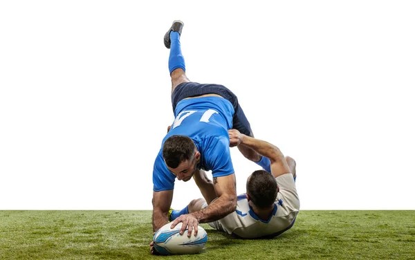 Dois atletas, jogadores de rugby a jogar rugby football no chão da relva isolado no fundo branco. Esporte, atividade, saúde, hobby, conceito de ocupações — Fotografia de Stock