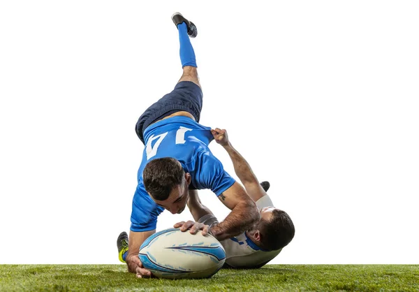 Beyaz arka planda izole edilmiş çimlerde rugby oynayan erkek rugby oyuncularının dinamik portresi. Spor, etkinlik, sağlık, hobi, meslek kavramı — Stok fotoğraf