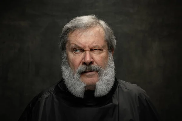 Duygusal yaşlı sakallı bir adamın dramatik portresi. Koyu renkli arka planda sakal tımar ettiriyor. Duyguların kavramı, moda, güzellik, kendini yeniden keşfetme — Stok fotoğraf