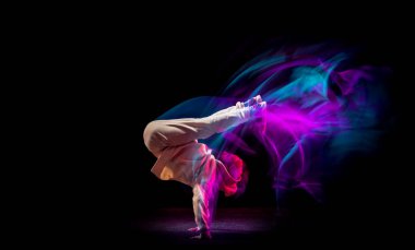 Hip-hop dansı yapan genç ve esnek bir çocuğun dinamik portresi ya da karışık pembe ışıkta siyah arka planda break dans. Spor, sanat, aksiyon, hareketler