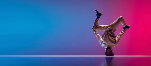 Flyer met jonge flexibele sportieve man die breakdance danst in witte outfit op een helderroze blauwe achtergrond. Concept van actie, kunst, schoonheid, sport, jeugd — Stockfoto