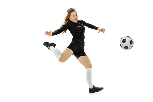 Pontapé na perna. Uma menina esportiva, treinando jogadora de futebol feminino com bola de futebol isolada no fundo do estúdio branco. Esporte, ação, movimento, fitness — Fotografia de Stock