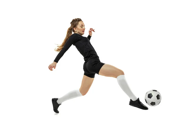 Treino. Uma menina esportiva, jogadora de futebol praticando com bola de futebol isolada no fundo do estúdio branco. Esporte, ação, movimento, fitness — Fotografia de Stock