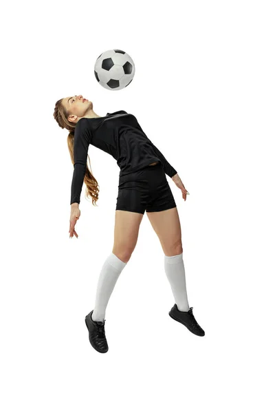 Saltando. Una chica deportiva, jugadora de fútbol femenina entrenando con pelota de fútbol aislada sobre fondo blanco del estudio. Deporte, acción, movimiento, fitness —  Fotos de Stock