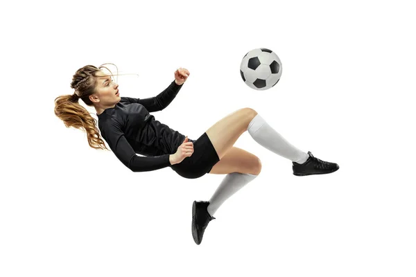 Patada en las piernas. Una chica deportiva, jugadora de fútbol femenina entrenando con pelota de fútbol aislada sobre fondo blanco del estudio. Deporte, acción, movimiento, fitness —  Fotos de Stock