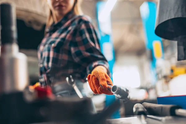 Mecánica automotriz. hermosa chica pelirroja joven en proceso de trabajo en la estación de servicio de automóviles, en el interior. Igualdad de género. Trabajo, ocupación, moda, trabajo —  Fotos de Stock