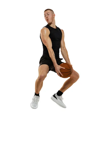 Retrato dinâmico de homem musculado, jogador de basquete pulando com bola isolada no fundo do estúdio branco. Esporte, movimento, conceitos de atividade. — Fotografia de Stock