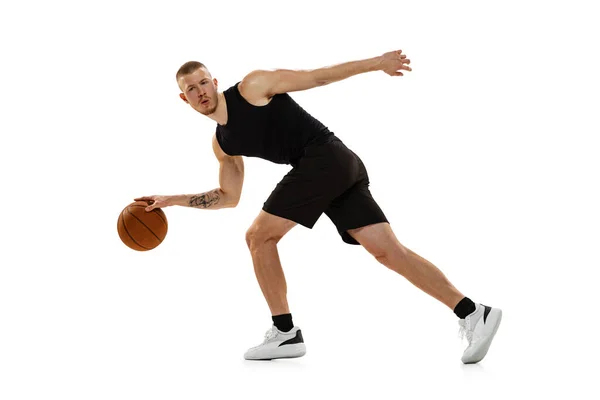 Jeune homme musclé, joueur de basket pratiquant avec balle isolé sur fond de studio blanc. Sport, mouvement, concepts d'activité. — Photo