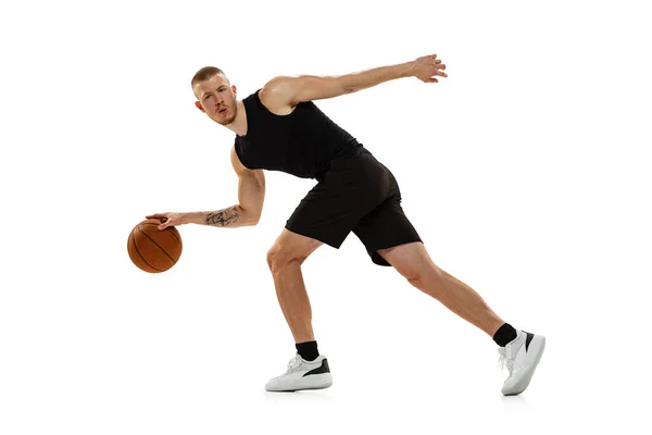 Joven musculoso, jugador de baloncesto practicando con pelota aislada sobre fondo blanco del estudio. Deporte, movimiento, conceptos de actividad. — Foto de Stock