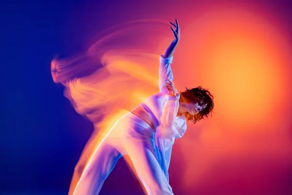 Спорт и красота. Изображение гибкой молодой девушки, танцовщицы хип-хопа в белом наряде танцевальный хип-хоп изолирован на синем фоне в желтом неоновом свете. — стоковое фото