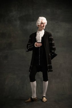 Amadeus Mozart 'ın resmindeki genç adam. Koyu yeşil renkli arka planda izole edilmiş bir ortaçağ insanı. Retro biçimi, dönemin karşılaştırması.