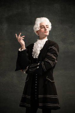 Amadeus Mozart 'ın resmindeki genç adam. Koyu yeşil renkli arka planda izole edilmiş bir ortaçağ insanı. Retro biçimi, dönemin karşılaştırması.