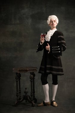 Amadeus Mozart 'ın resmindeki genç adam. Koyu yeşil renkli arka planda izole edilmiş bir ortaçağ insanı. Retro biçimi, dönemin karşılaştırması.