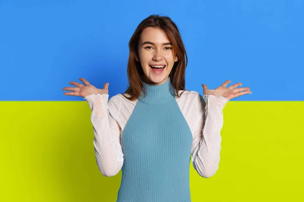 Retrato de jovem mulher bonita sorrindo isolado sobre azul e amarelo fundo bandeira ucraniana. Parece feliz. — Fotografia de Stock