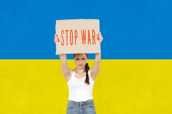 Konzeptionelles Bild. Junges Mädchen hält Tablet mit Stopp-Krieg-Schriftzug isoliert über ukrainischem Flaggenhintergrund — Stockfoto