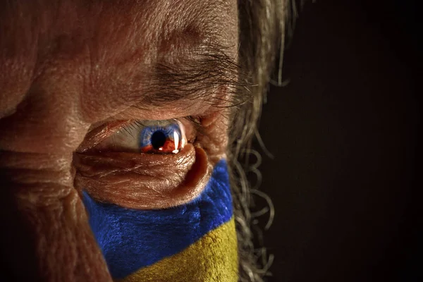 Чоловіче око зблизька з кольорами прапора України на щоці. Стоп війни, стояти за Україну. Припиніть бомбардувати українці. — стокове фото