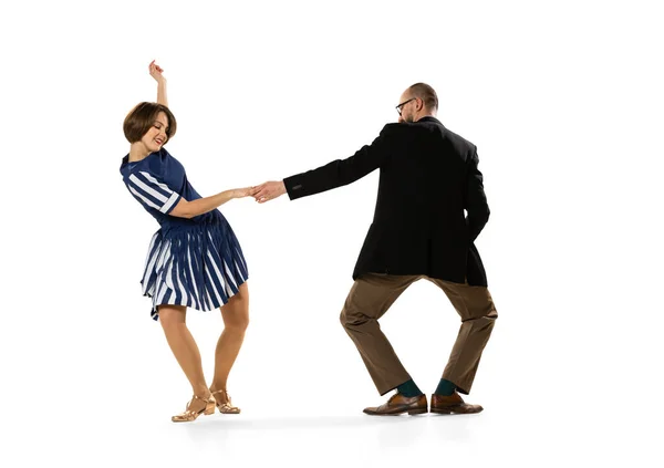 Heureux jeune homme et femme dans des tenues de style rétro vintage dansant danse lindy hop isolé sur fond blanc. Traditions intemporelles, style mode des années 60, 70. — Photo