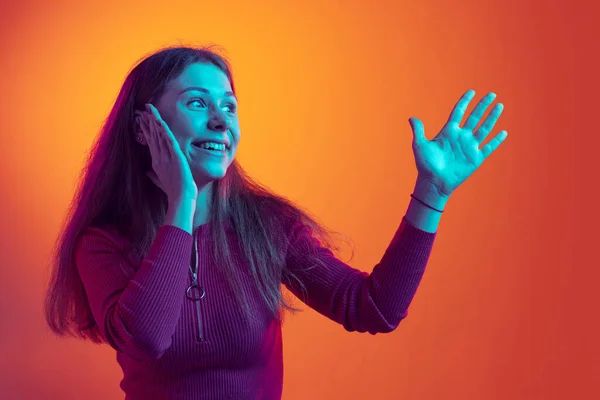 Jeden emocionální mladá krásná póza izolované na oranžovém pozadí v neonovém světle, filtr. Pojetí emocí, hudby, krásy — Stock fotografie