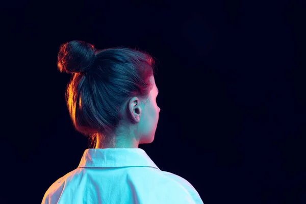 Visão traseira da menina em camisa branca isolada no fundo escuro em luz de néon azul, filtro. Conceito de emoções, moda, juventude — Fotografia de Stock