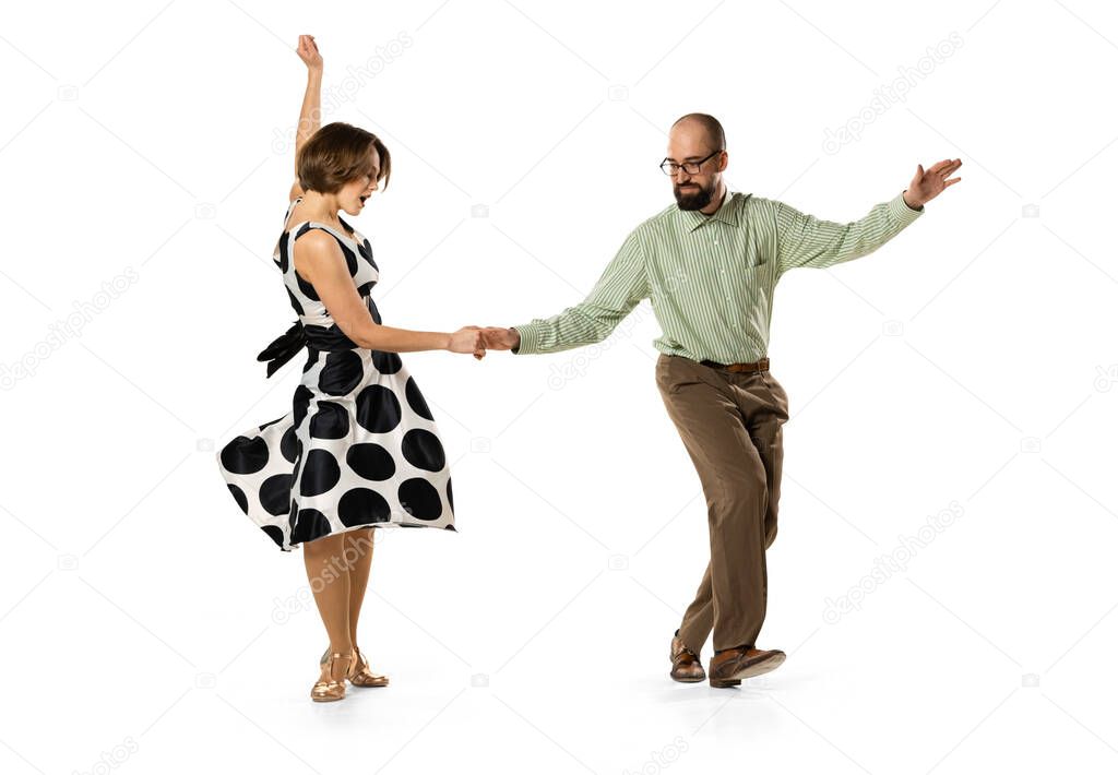 Dynamic portrait of couple of dancers in vintage retro style outfits dancing lindy hop dance isolated on white background. Concept of art, action, motion