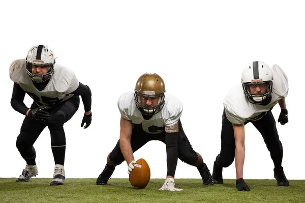 Three young sportive men, professional american football players in sports uniform and equipment in action isolated on white background. — Stock Photo, Image