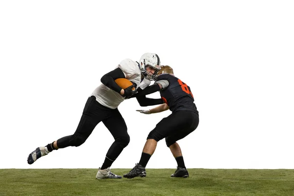 Zwei männliche American-Football-Spieler spielen während eines Sportspiels auf dem Rasenboden isoliert auf weißem Hintergrund. Konzept des Sports, Herausforderungen, Ziele, Stärke. Plakat, Banner für Werbung — Stockfoto