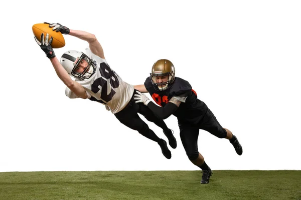 Twee mannelijke amerikaanse voetballers spelen tijdens de sport wedstrijd op gras vloeren geïsoleerd op witte achtergrond. Concept van sport, uitdagingen, doelen, kracht. Affiche, banner voor reclame — Stockfoto