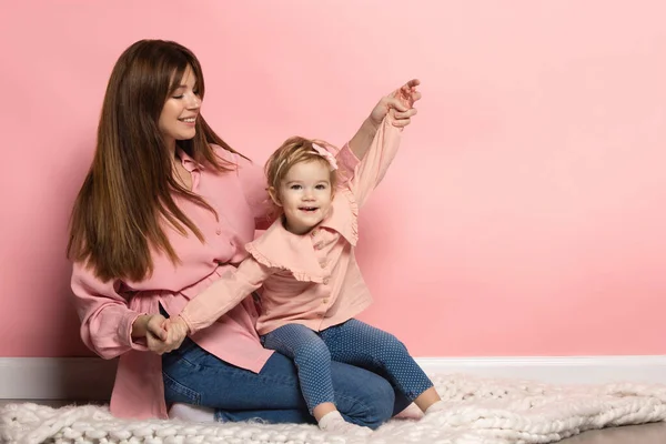 Sueños. Retrato de mujer joven y niña, madre e hija aisladas sobre fondo de estudio rosa. Celebración del Día de las Madres. Concepto de familia, infancia, maternidad — Foto de Stock