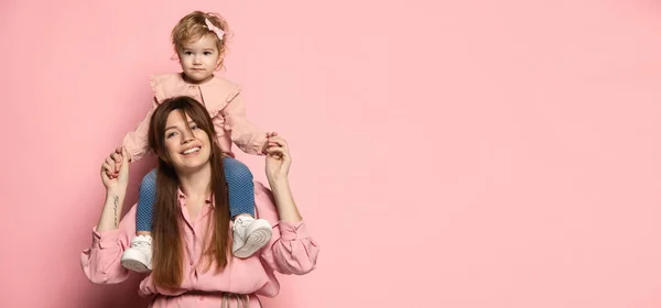 Volante con mujer feliz y niña, madre e hija cuidadoras aisladas en el fondo del estudio rosa. Celebración del Día de las Madres. Concepto de familia, infancia, maternidad — Foto de Stock