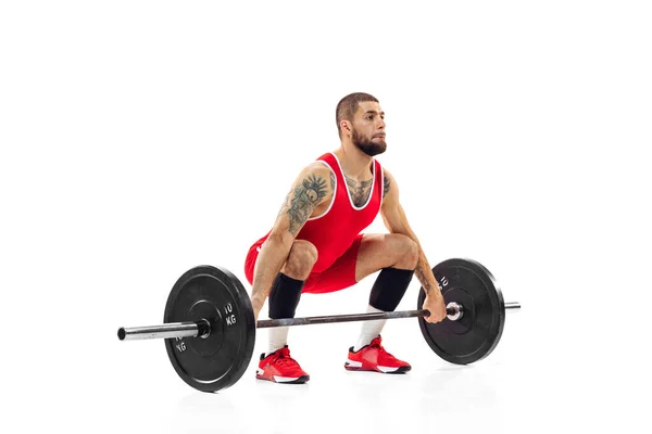 Full length portret van de mens in rode sportkleding oefenen met een gewicht geïsoleerd op witte achtergrond. Sport, gewichtheffen, kracht, prestaties concept — Stockfoto