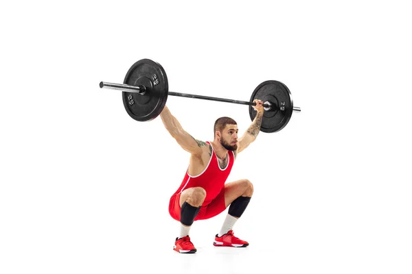 Portret van een man in rode sportkleding die traint met een gewicht geïsoleerd op een witte achtergrond. Sport, gewichtheffen, kracht, prestaties concept — Stockfoto