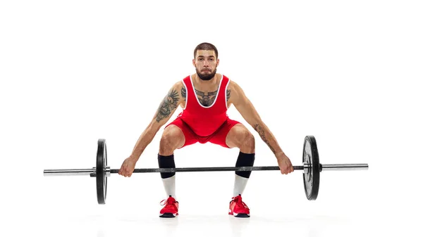 Full length portret van de mens in rode sportkleding oefenen met een gewicht geïsoleerd op witte achtergrond. Sport, gewichtheffen, kracht, prestaties concept — Stockfoto