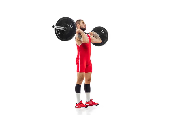 Retrato completo del hombre en ropa deportiva roja haciendo ejercicio con un peso aislado sobre fondo blanco. Deporte, levantamiento de pesas, poder, concepto de logros —  Fotos de Stock