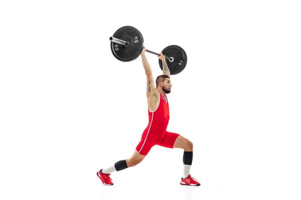 Retrato completo del hombre en ropa deportiva roja haciendo ejercicio con un peso aislado sobre fondo blanco. Deporte, levantamiento de pesas, poder, concepto de logros — Foto de Stock