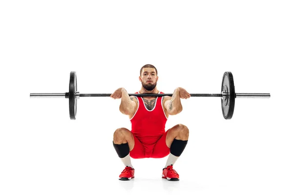 Portrait complet de l'homme en tenue de sport rouge s'exerçant avec un poids isolé sur fond blanc. Sport, haltérophilie, puissance, concept de réalisations — Photo
