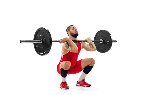 Portrait complet de l'homme en tenue de sport rouge s'exerçant avec un poids isolé sur fond blanc. Sport, haltérophilie, puissance, concept de réalisations — Photo