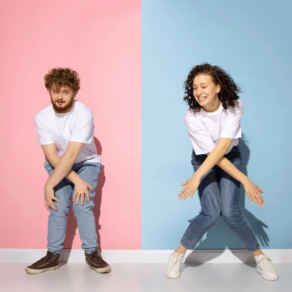 Συναισθηματικό ζευγάρι των νέων αστεία και ευτυχισμένη άνθρωπος και κορίτσι χορό hip-hop στο στούντιο σε μπλε και ροζ μοντέρνο φόντο χρώμα. — Φωτογραφία Αρχείου