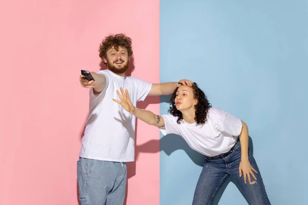 Casado casal, jovem homem emotivo e menina isolado no fundo de cor azul e rosa na moda. Emoções humanas, cuidado, conceito de relacionamentos — Fotografia de Stock