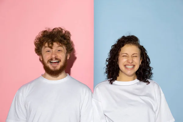 Half length portrait of young emotive man and girl making faces isolated on blue and pink trendy color background. Human emotions concept — Stock Photo, Image