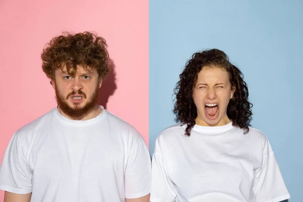 Half length portrait of young emotive man and girl shouting isolated on blue and pink trendy color background. Human emotions concept — Stock Photo, Image