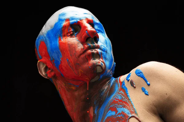 Imagem conceitual. Cabeça masculina coberta com cores azul, branco e vermelho da bandeira russa isolada sobre fundo preto — Fotografia de Stock