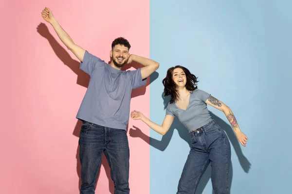 Νέοι ενθουσιασμένοι ζευγάρι αστεία και χαρούμενος άνθρωπος και κορίτσι που χορεύουν hip-hop, έχοντας τη διασκέδαση απομονώνονται σε μπλε και ροζ μοντέρνο χρώμα φόντο. Έννοια συναισθημάτων — Φωτογραφία Αρχείου